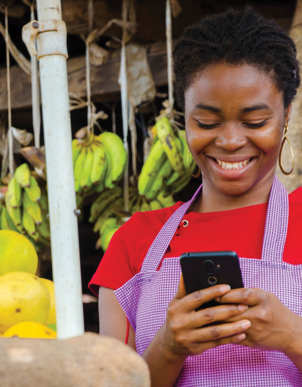 a young beautiful african market woman feeling happy about what she saw on her cellphone